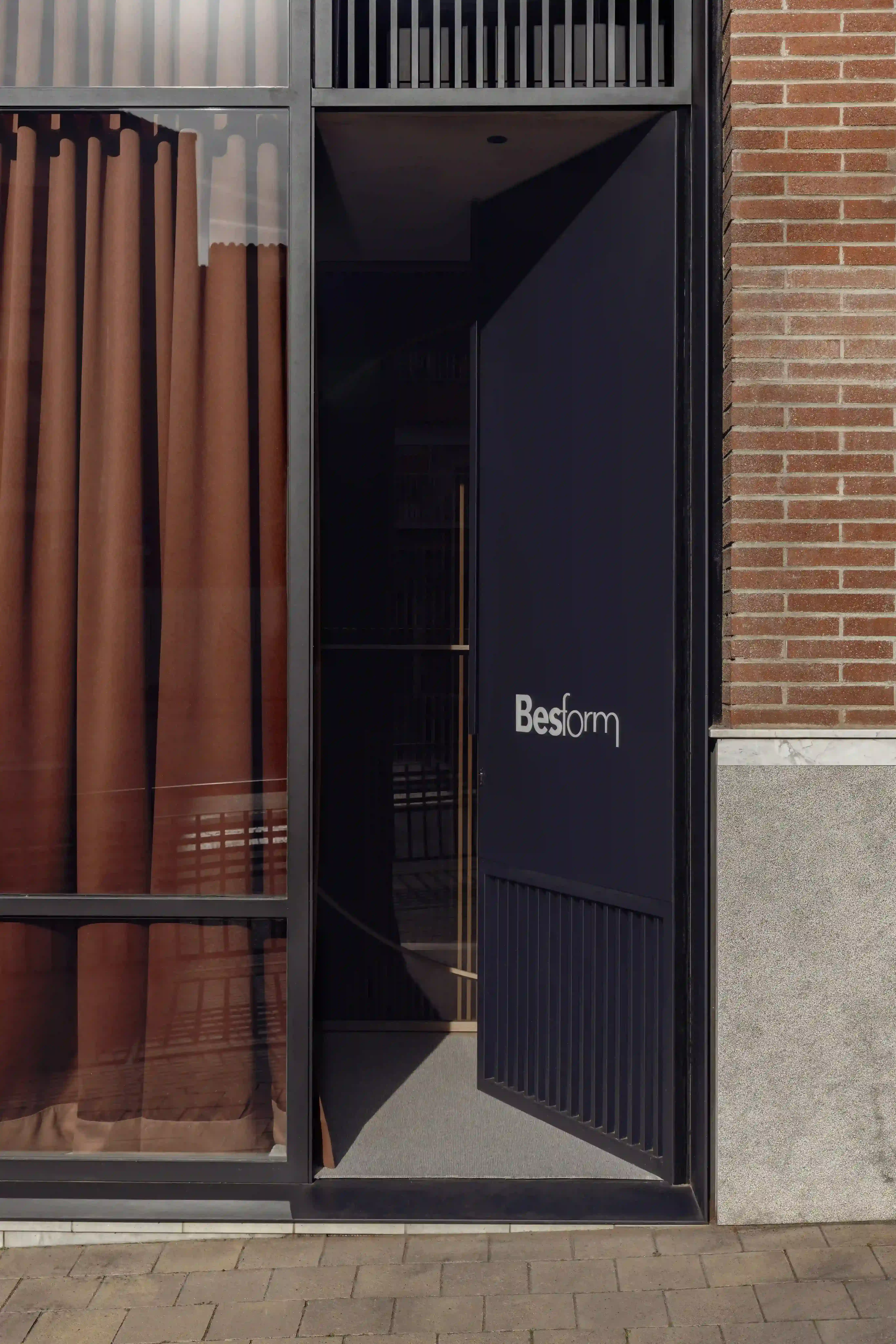 Entrada de showroom Besform con fachada contemporánea y acabados metálicos