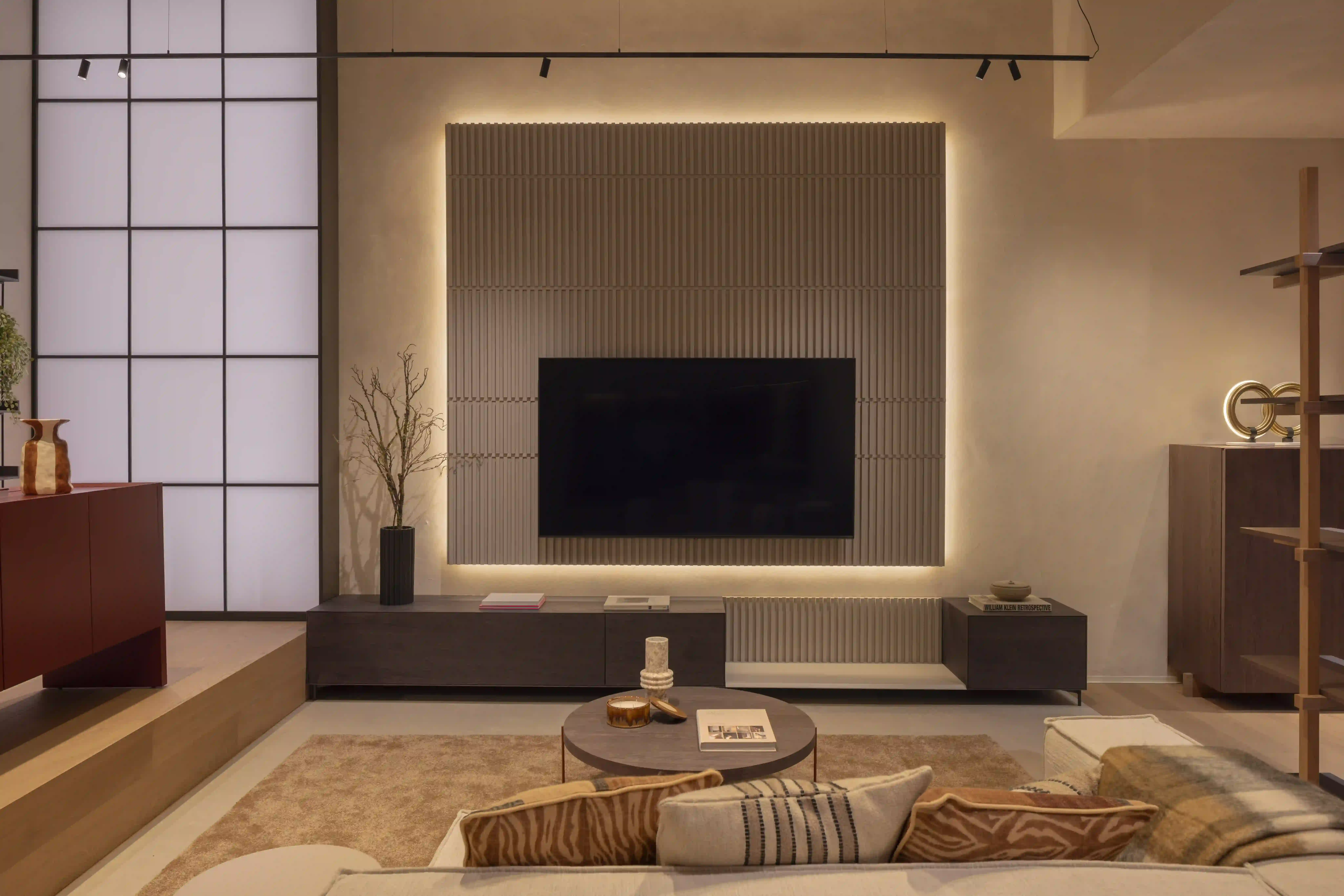 Zona de salón con mueble de televisión y panel decorativo iluminado