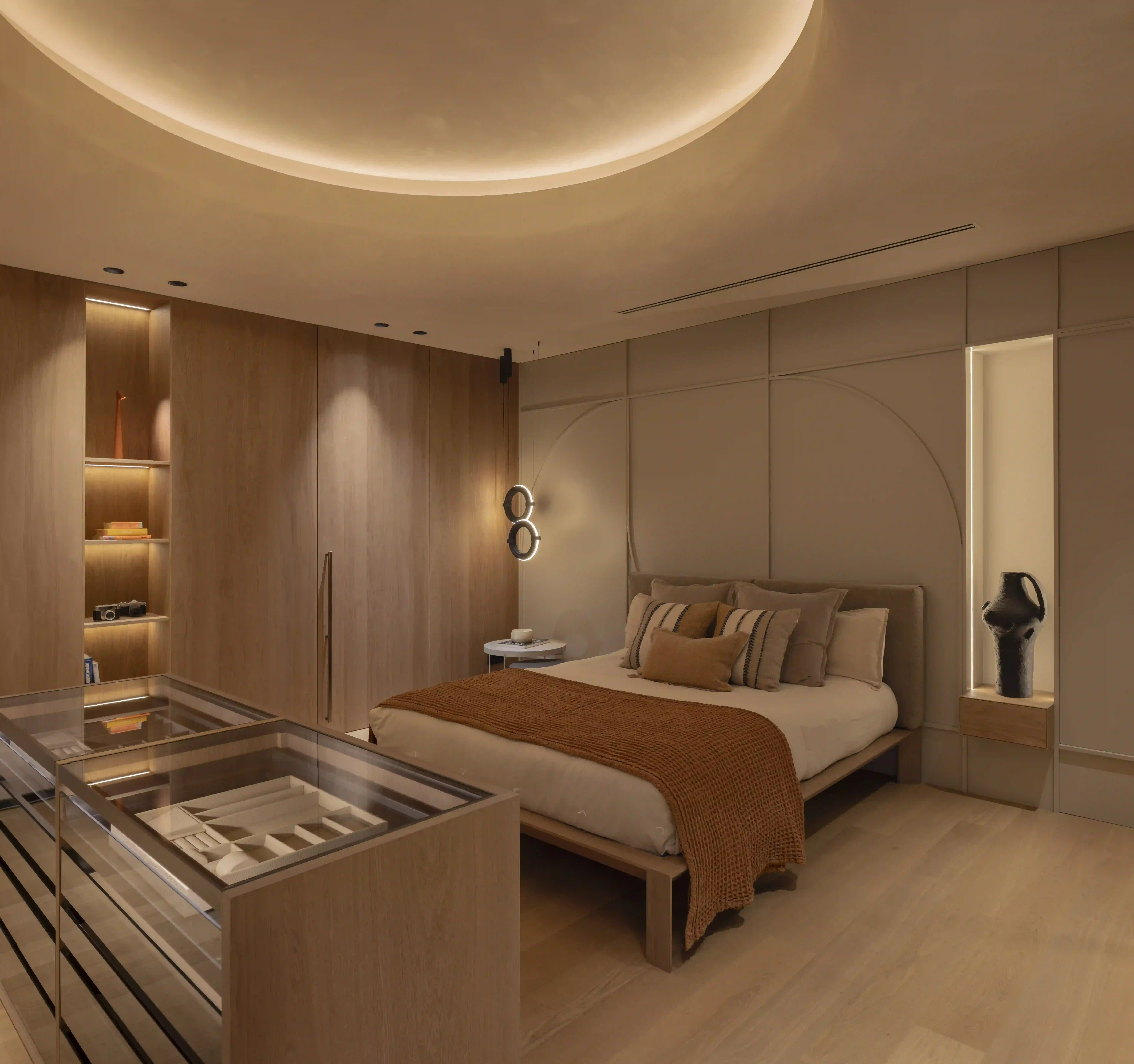 Dormitorio de diseño con vestidor integrado, cabecero decorativo e iluminación indirecta<br />
